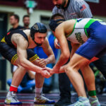 Two wrestlers facing each other in a neutral stance during a match.