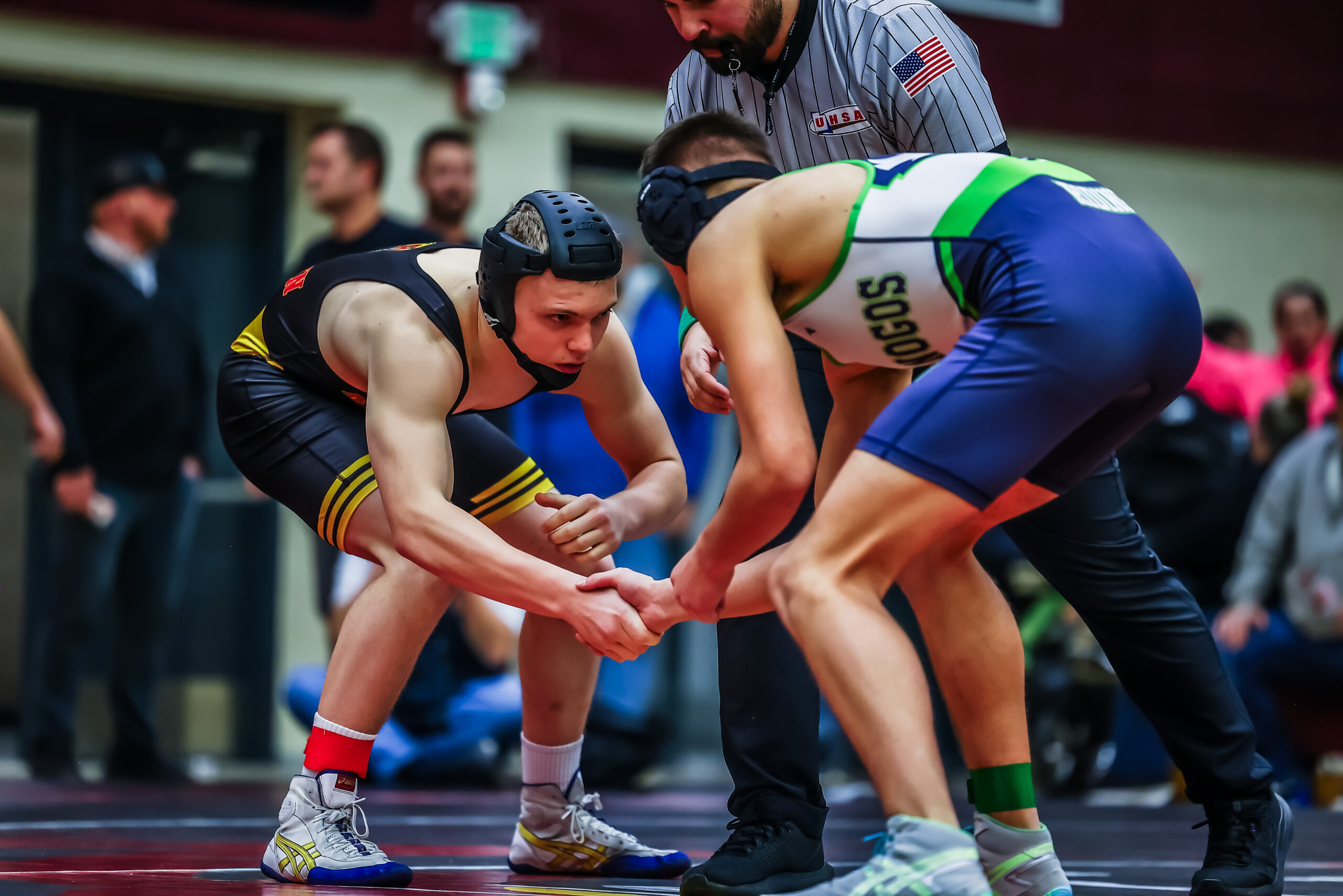 Two wrestlers facing each other in a neutral stance during a match.